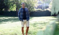 Kevin Lötscher steht gelassen auf einer Wiese und lächelt in die Kamera.